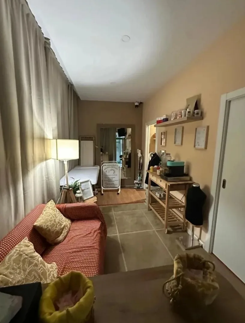 The centre's waiting room, with a sofa, a lamp and the treatment table in the background